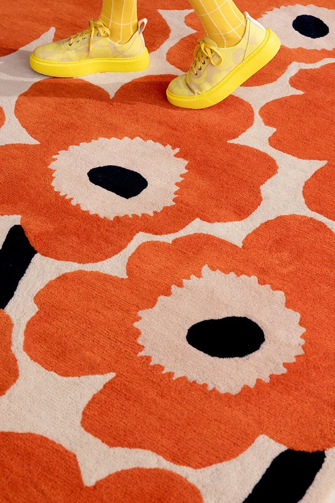 Marimekko rug in the classic poppy design with orange and black flowers and neutral beige background