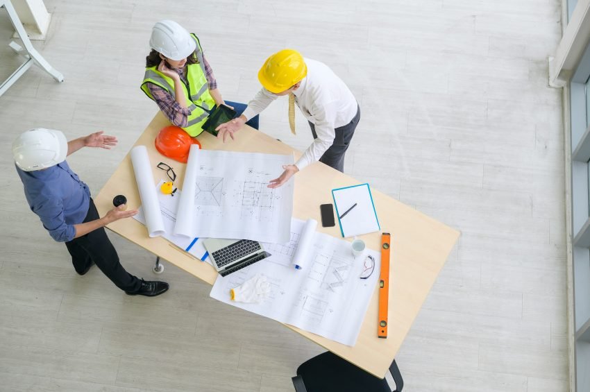 builder, project manager, architect, on building site checking architectural plans
